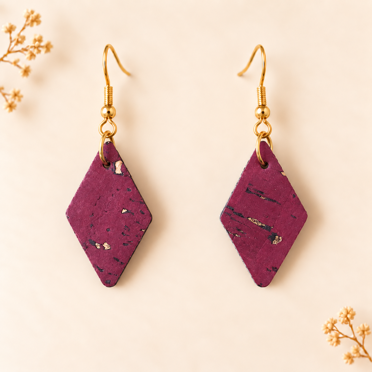 Earrings with diamond shaped wine colored cork fabric and gold colored hooks.