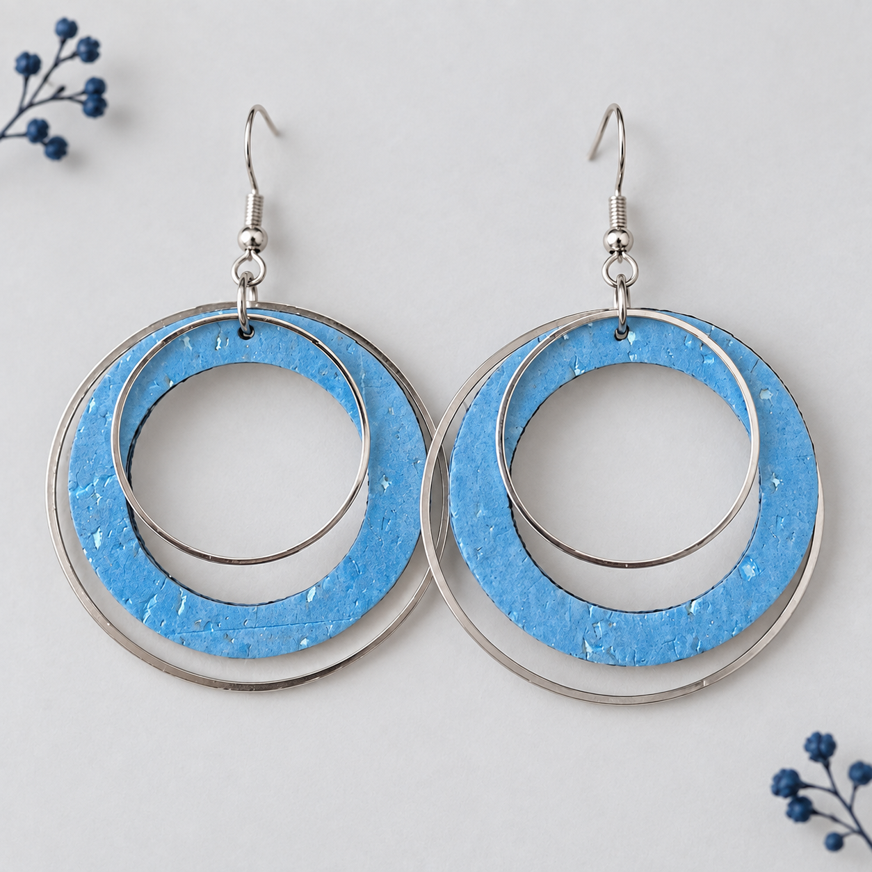 Metallic blue cork fabric earrings with overlapping silver color hoops.