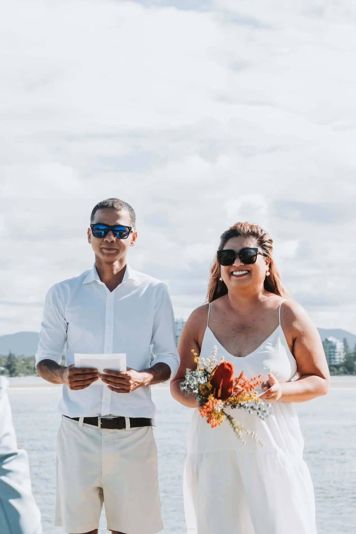 Couple in sunglasses by the water during an outdoor elopement