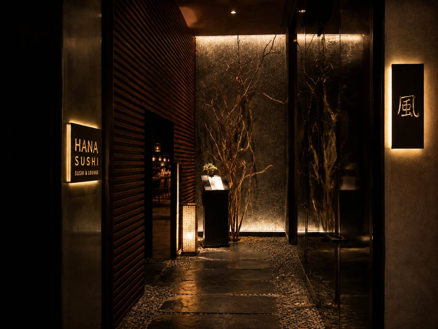 Entrance to Hana Sushi & Lounge with warm ambient lighting, decorative plants, and a sign displaying its name. Grand Hotel, lodz