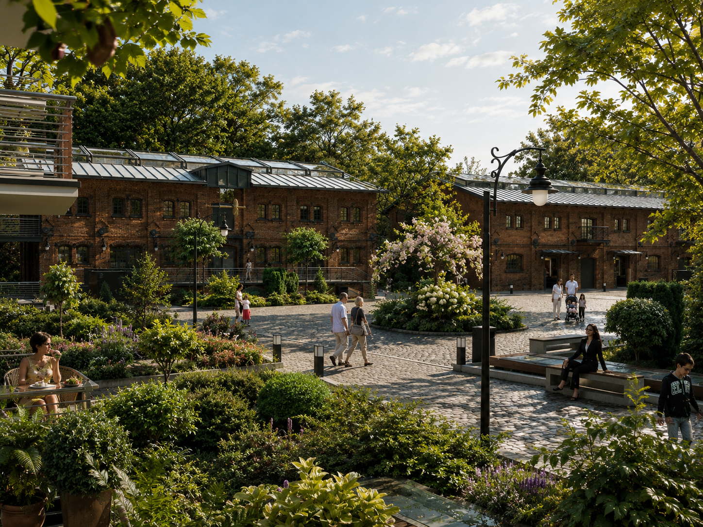 People walking and sitting in a lush, green park with flowering trees and cobblestone pathways, surrounded by red brick buildings. Folwark Scheiblera Łódź, Vertano, Park nad Jasieniem
