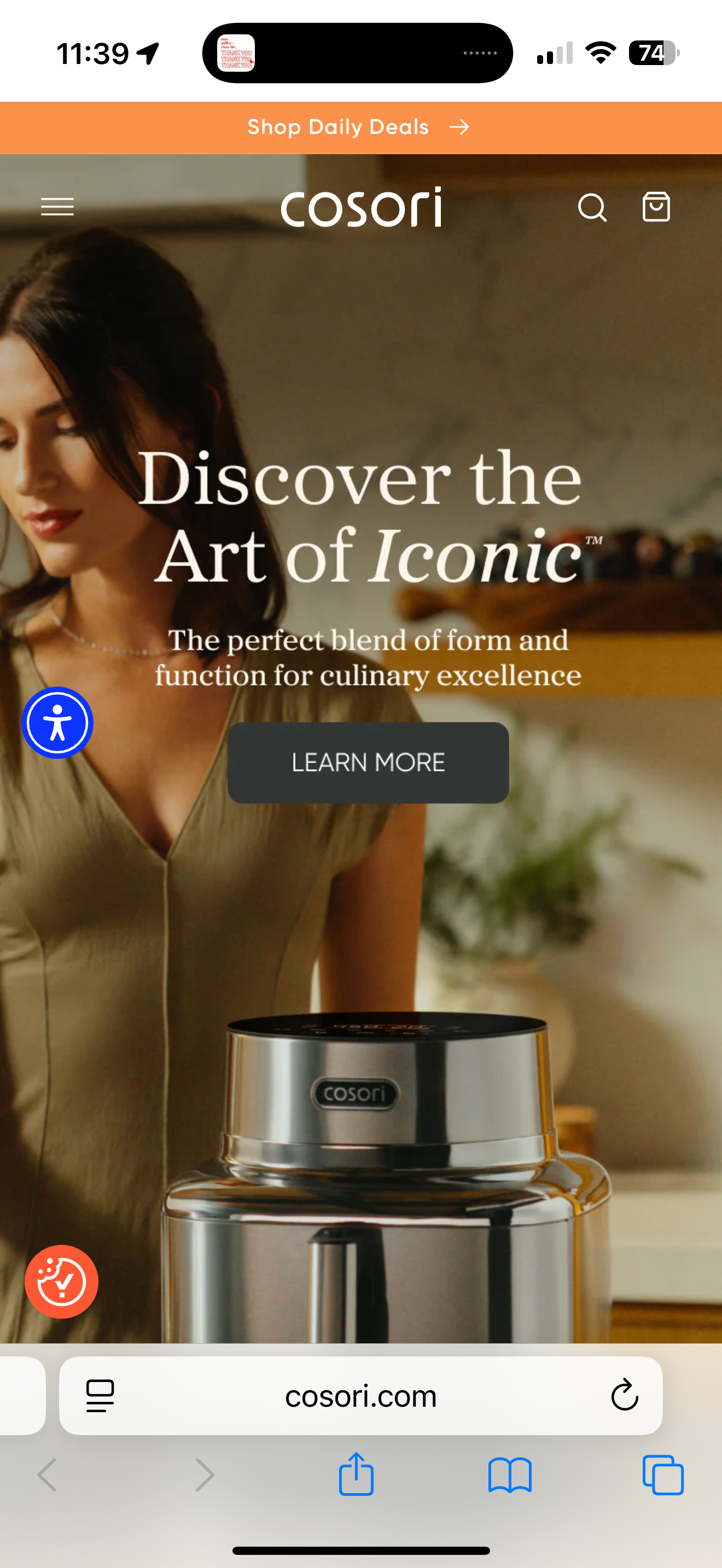A woman in a beige top standing next to a stainless steel kitchen appliance with a black top and the brand name "cosori" on the front.
