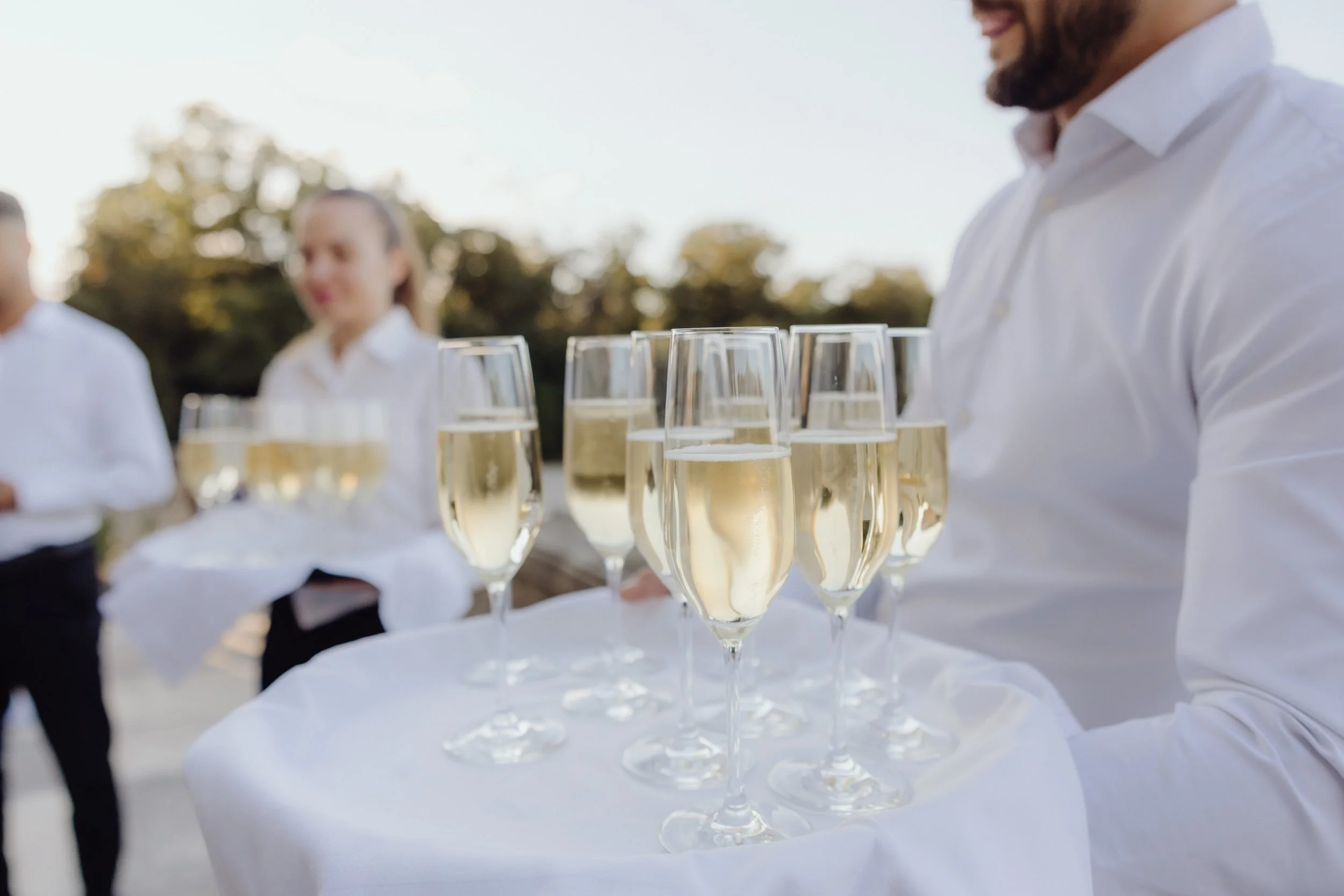 Elegant tray of champagne glasses ready to welcome guests at a wedding celebration.