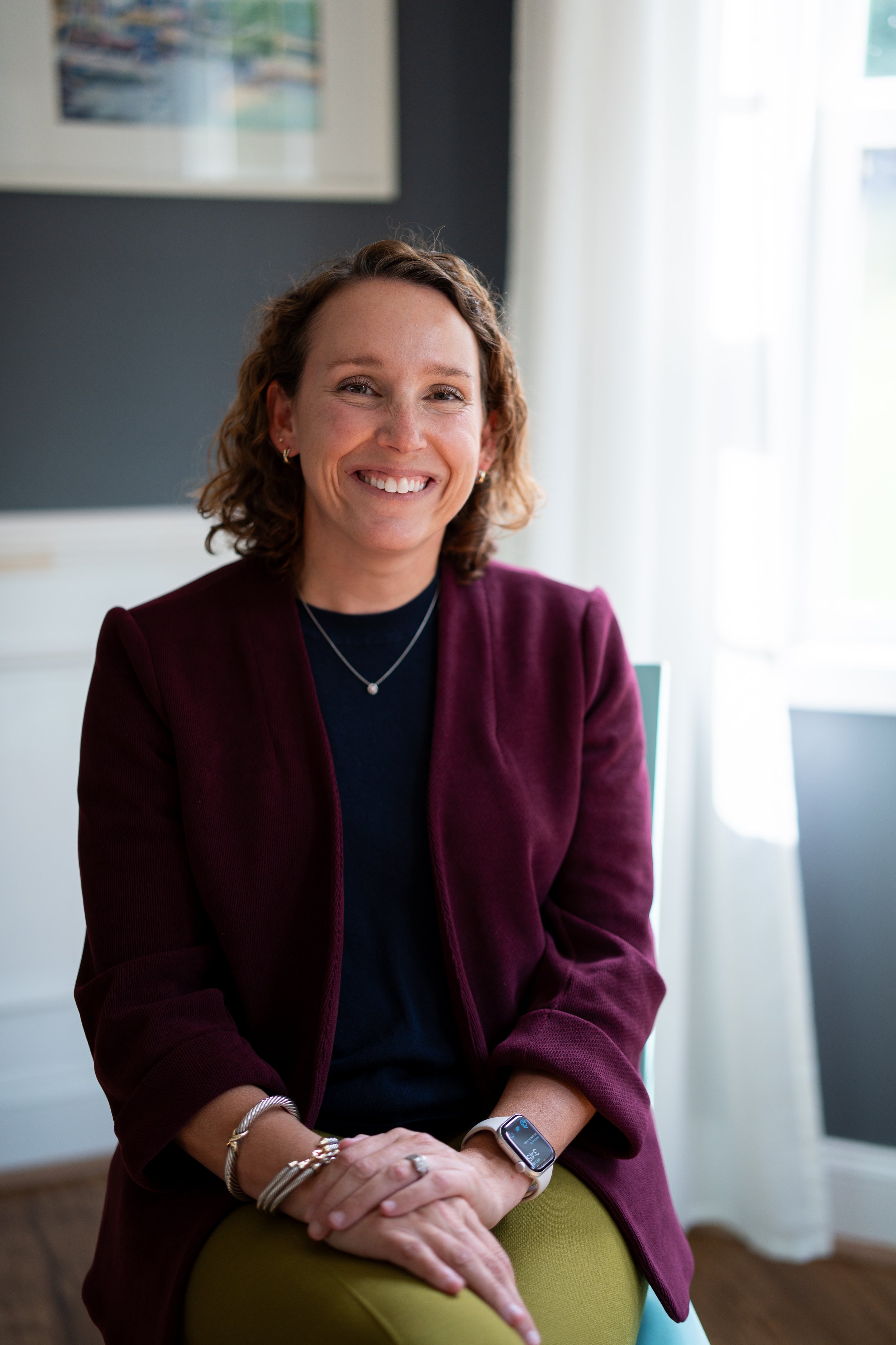 An image of a woman in an office smiling with a light background