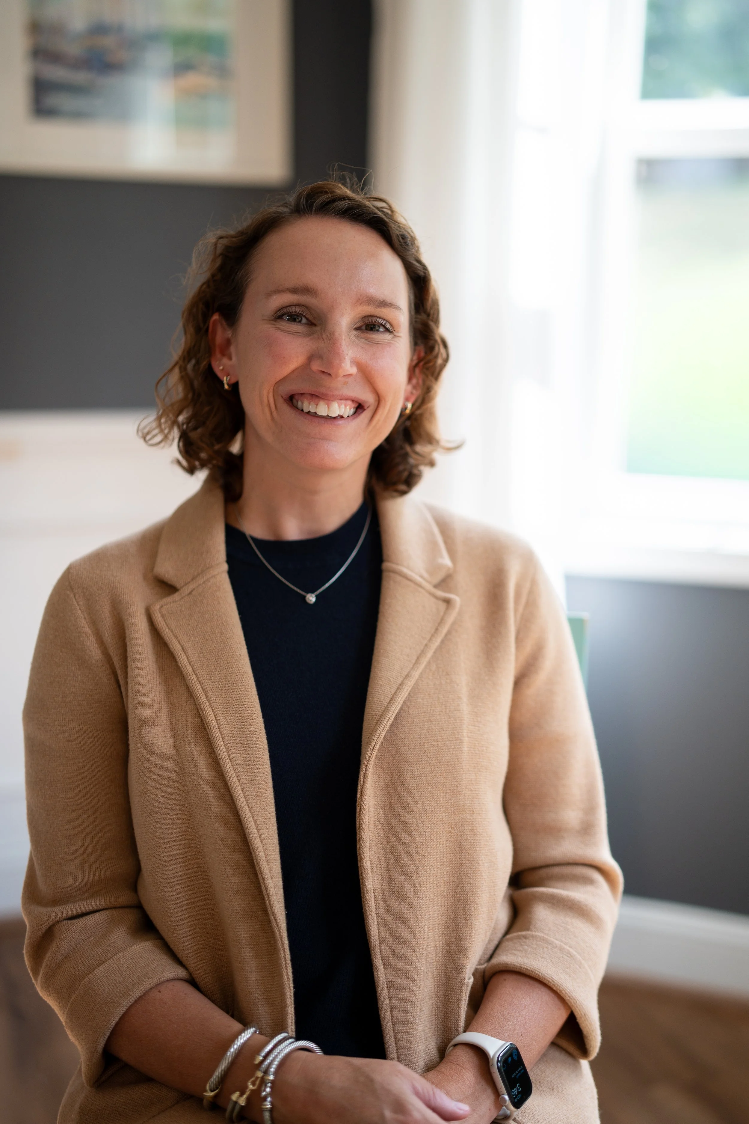A woman smiles in a cozy home office