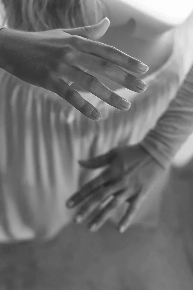 Black and white photo showing two hands with fingers extended, one hand positioned above the other.