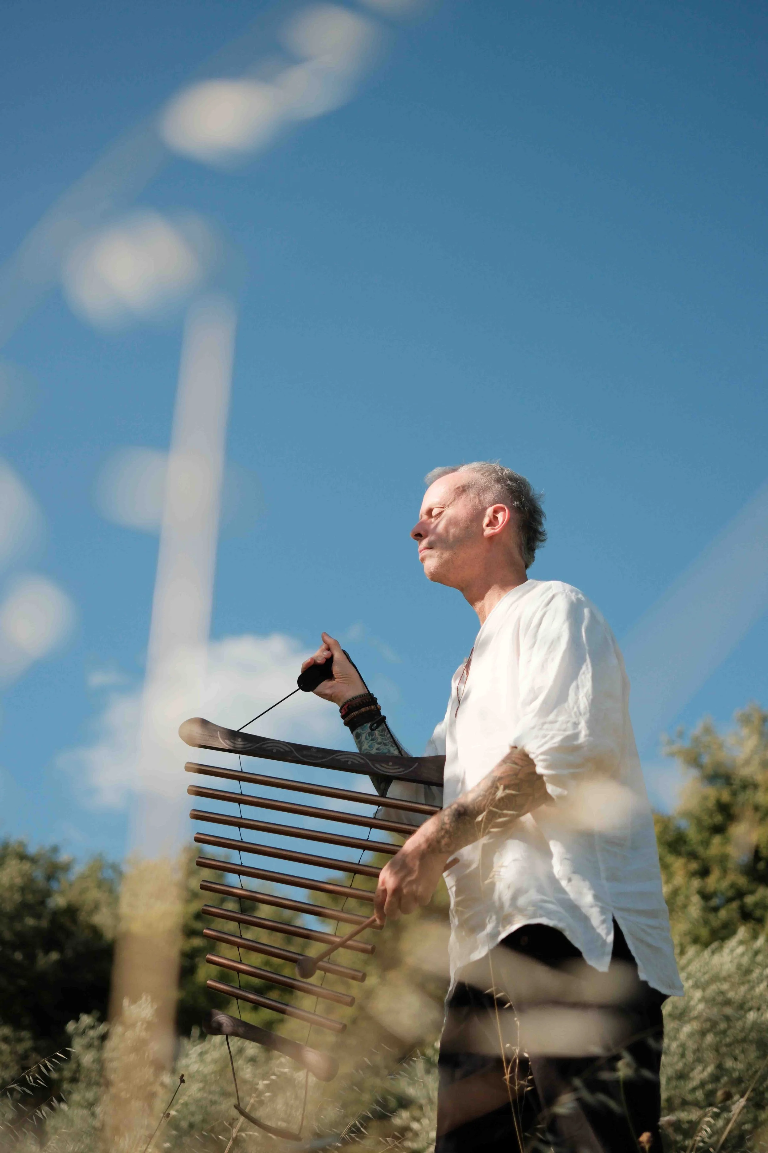Michael Reiley eyes closed playing chimes