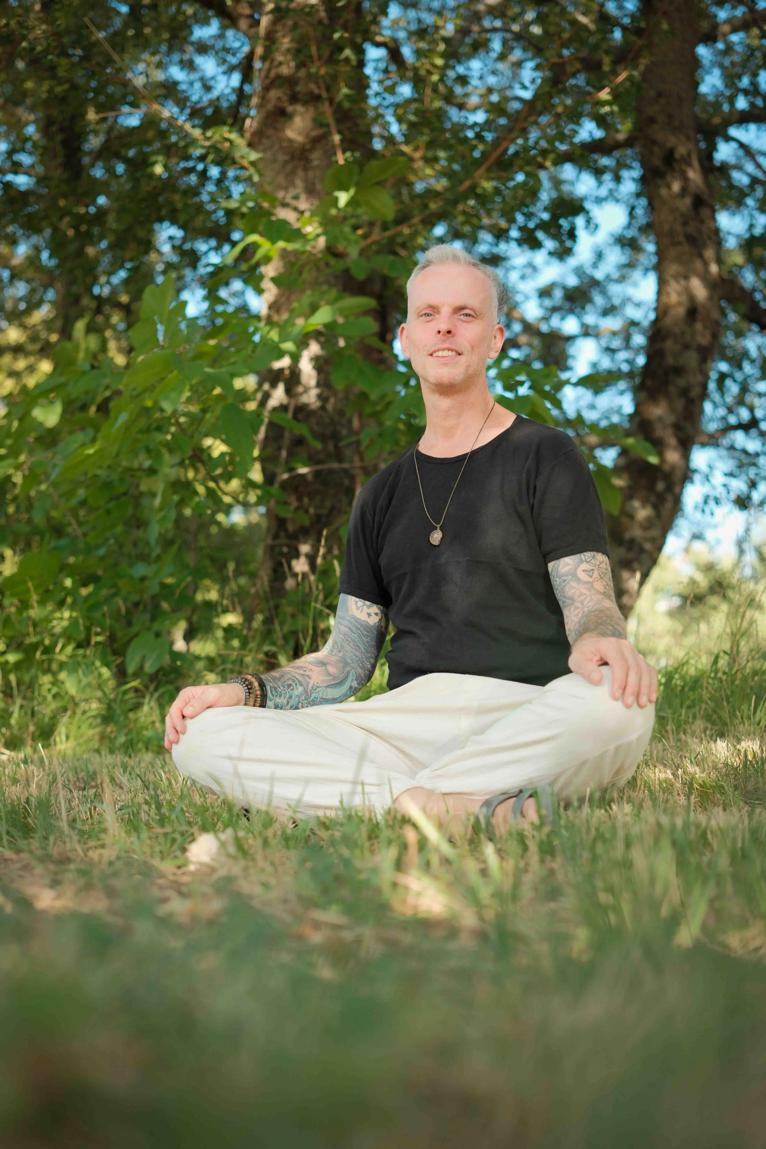 Michael Reiley sitting in a field smiling