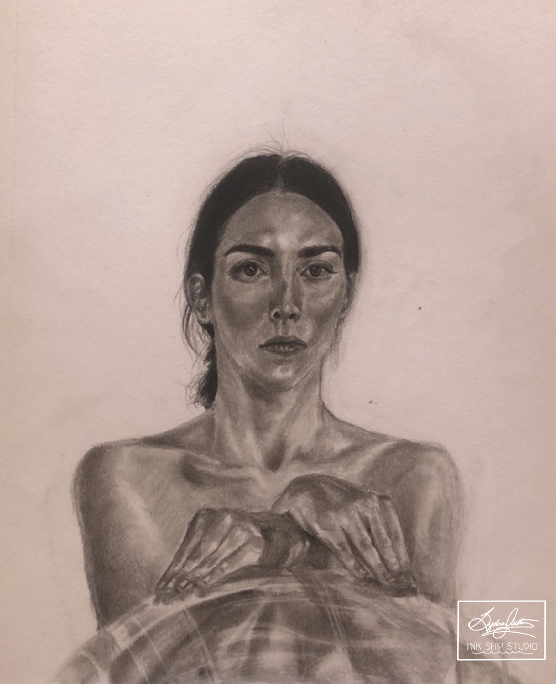 A realistic black and white pencil drawing of a woman with dark hair in a bun, looking directly at the viewer, with her arms crossed in front of her. She has a serious expression, and the drawing shows detailed facial features and shading.