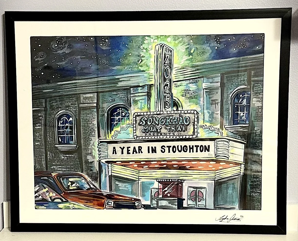 A colorful artistic poster for Song Khao Muay Thai gym, shown as a theater, featuring an illuminated marquee with the message 'A Year in Stoughton', surrounded by historic brick buildings, a parked brown car, and a night sky with stars.
