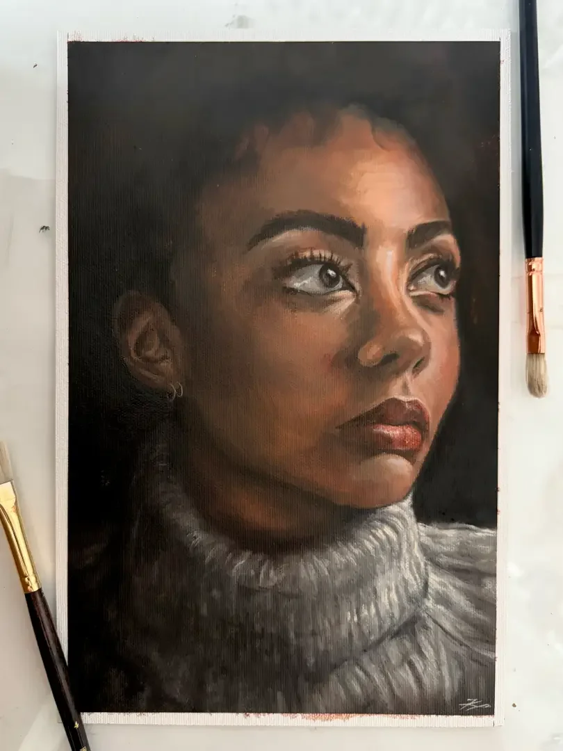 Close-up portrait of a woman with dark hair, wearing a gray knitted turtleneck sweater, looking upward with a contemplative expression. Sharp eyebrows and light makeup.