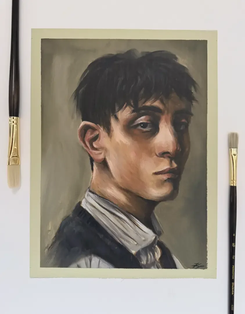 A portrait painting of a young man with dark hair, wearing a collared shirt and a dark sweater, with a serious expression, surrounded by two paintbrushes.