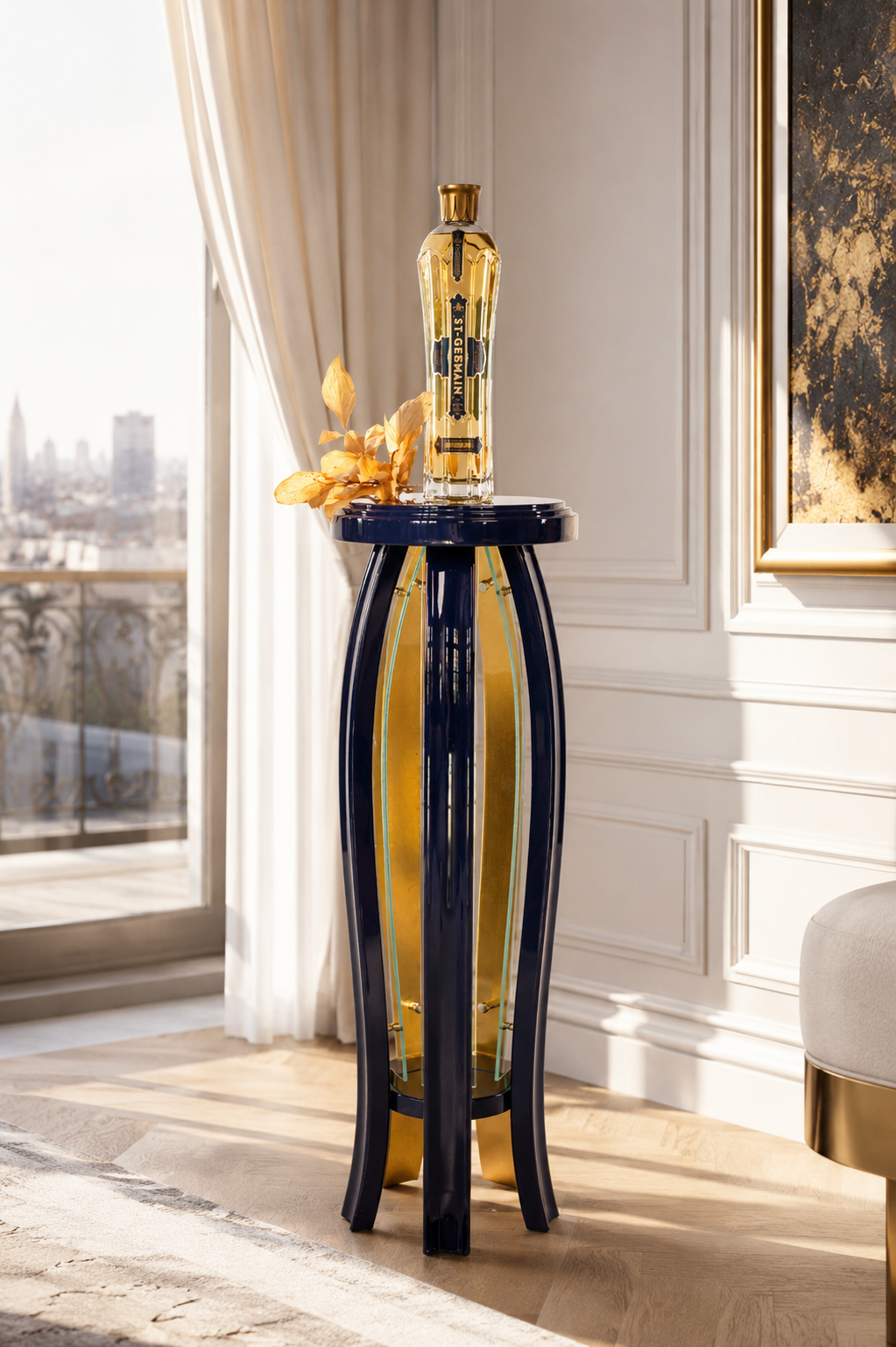 A tall decorative glass bottle with a gold cap and a black label is placed on a glossy black and gold pedestal table. There is a dried plant with brown leaves next to it, indoors near a window with white curtains, in a room with white paneled walls and a view of a city skyline.