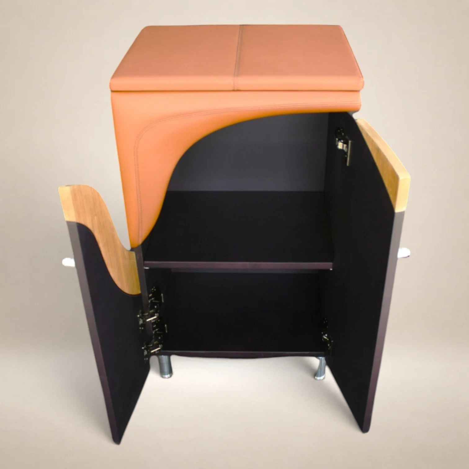 A black desk with open doors, showing storage space inside, and a light-colored cushioned top.