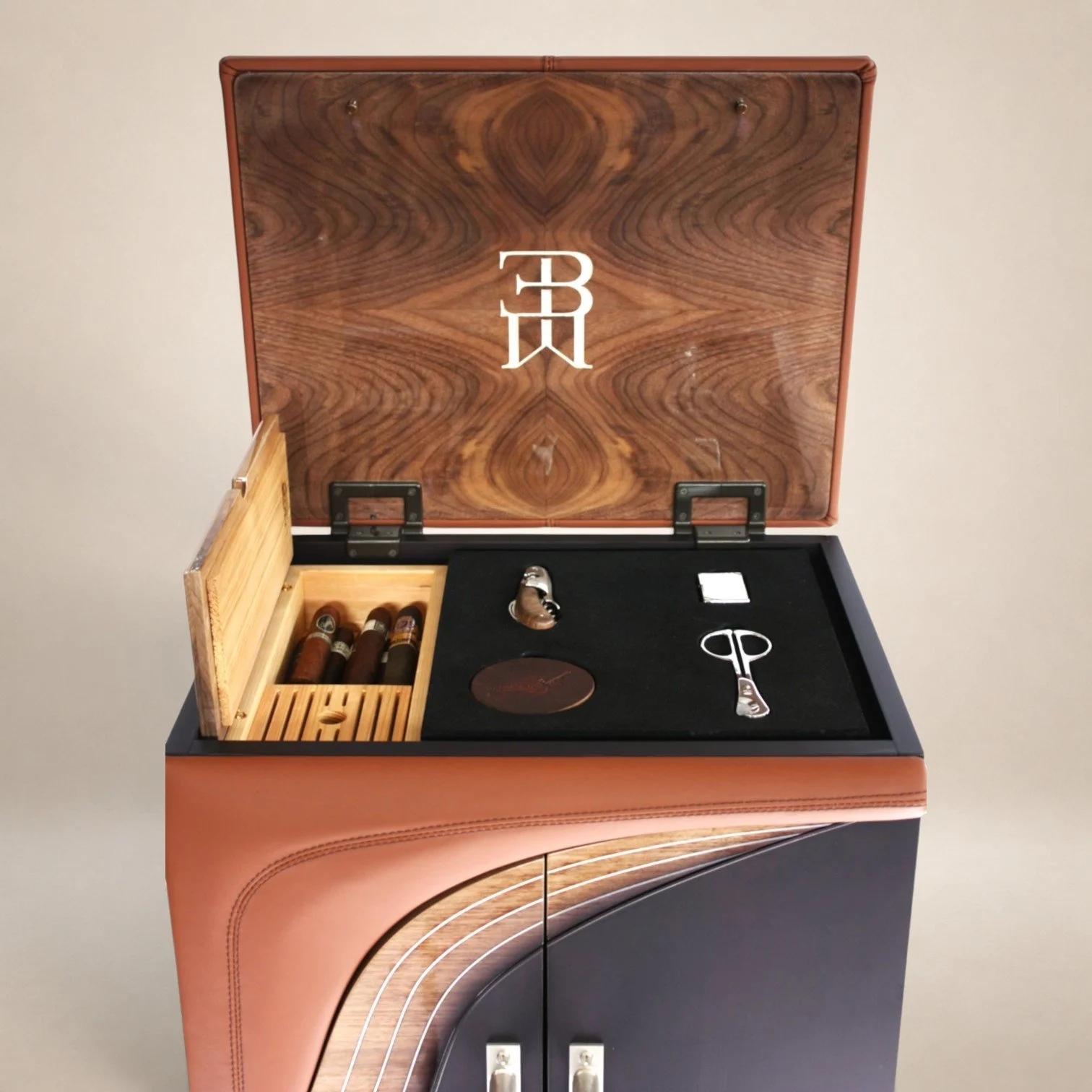 Open cigar humidor box with cigars inside, and a black display case with a cigar cutter, a small lighter, and a round ashtray on top.