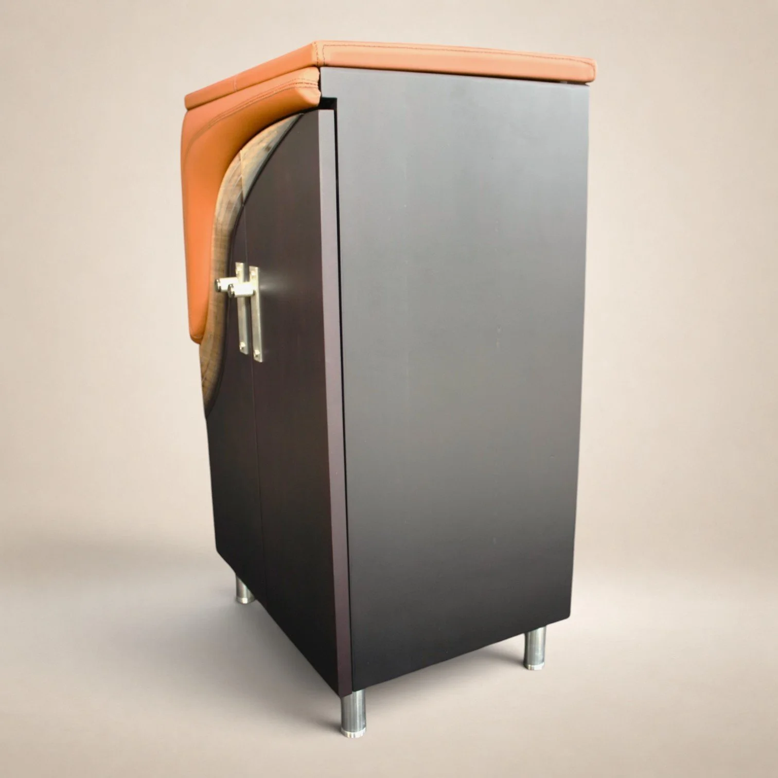 A black and gray office desk with a curved orange fabric cushion on one side and metallic legs.