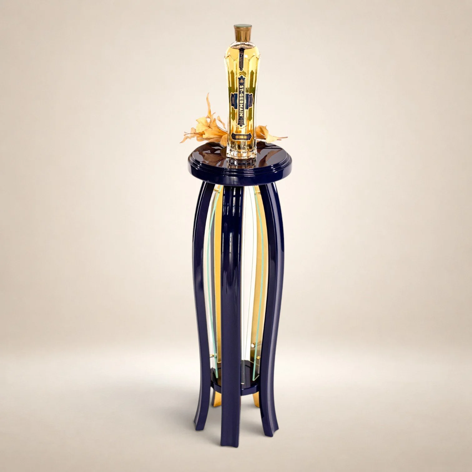 An art glass sculpture resembling a sword with a blue and yellow striped handle, standing on a tall blue stand, with dried flowers around the base, set against a plain light background.