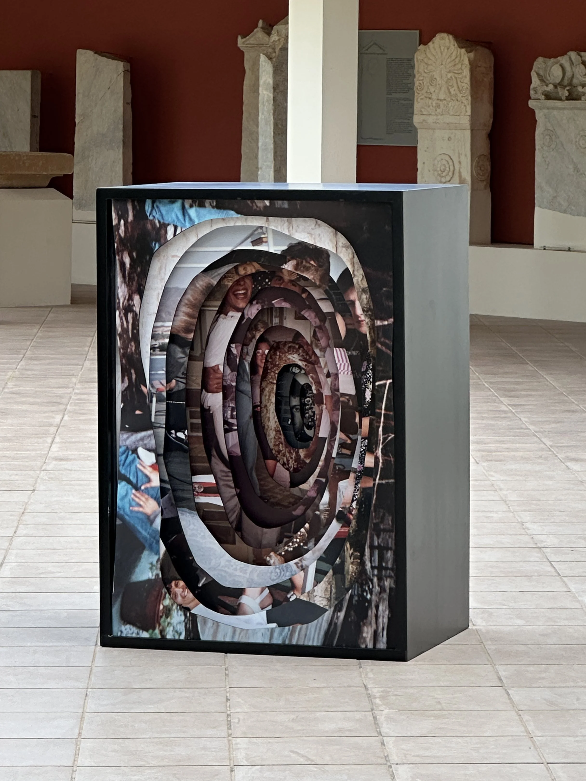 View through layered archival photographs in Memory Excavation, where partial family images coexist without a clear chronology.