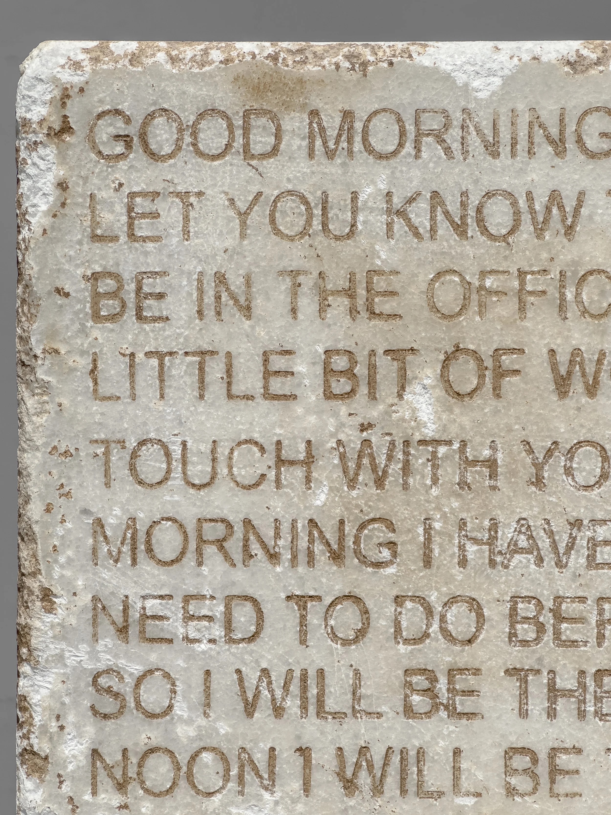 Detail of predictive autocomplete text inscribed on white Thassos marble in Love you, bye, contrasting digital ephemerality with ancient preservation.