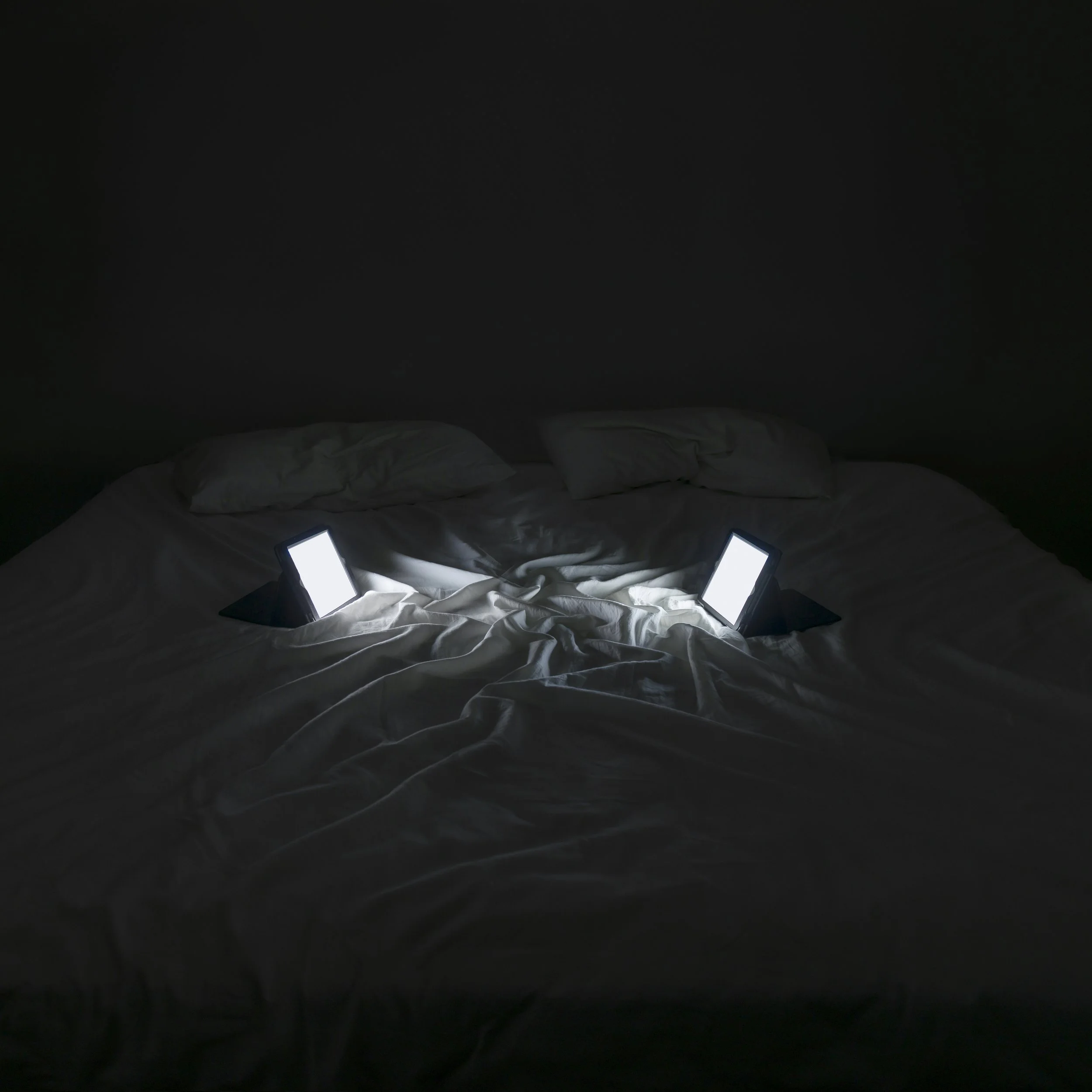 The Lovers from Family Portraits by Maria Mavropoulou, a staged photograph of glowing connected devices posed as an intimate couple, exploring digital intimacy and human–technology relationships.