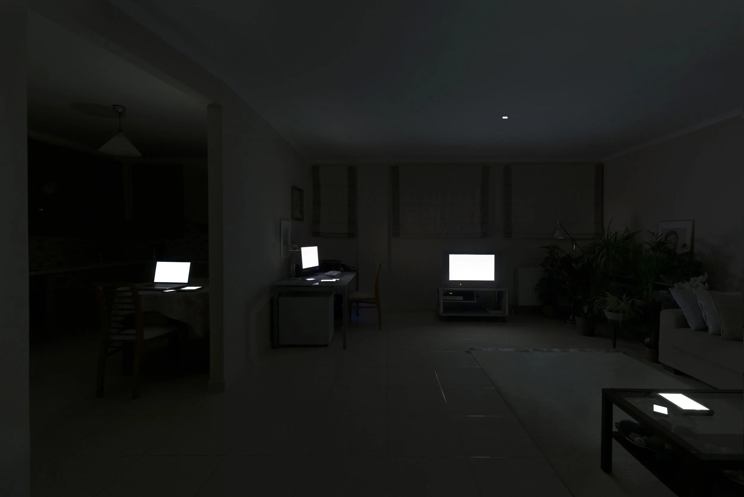 Movie Night from Family Portraits by Maria Mavropoulou, showing screens assembled in a familiar leisure scene and examining entertainment, social isolation and technology-mediated togetherness.