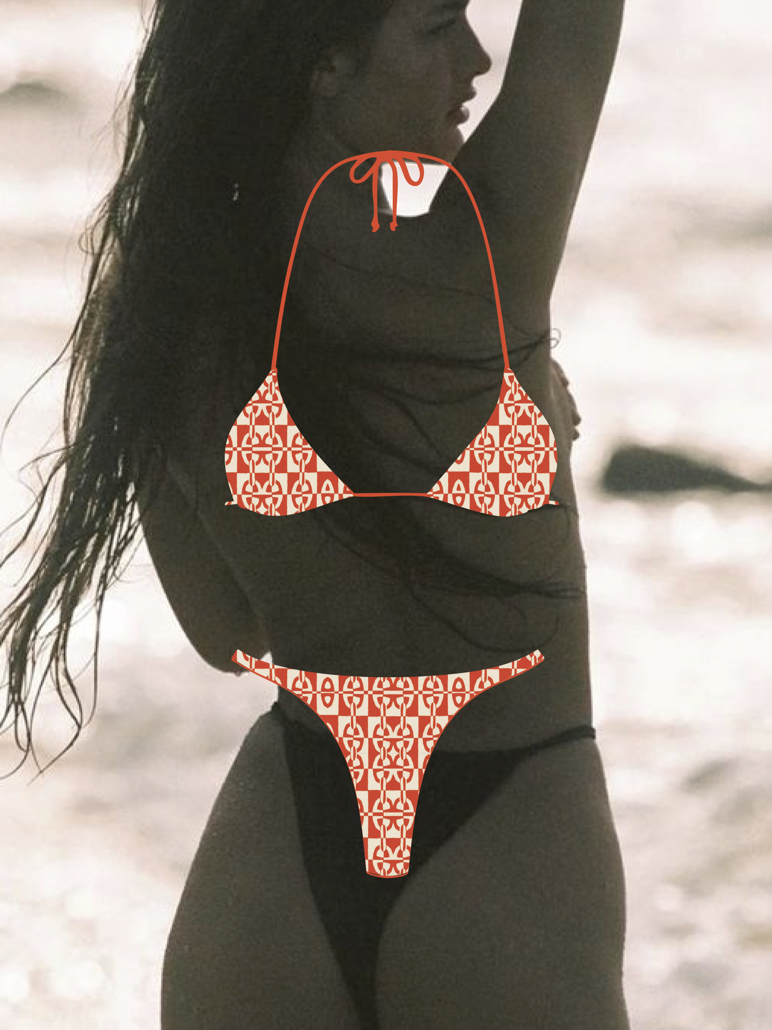 A woman in black swimsuit with patterned bikini overlay, with her arm raised, on a beach with cloudy sky.