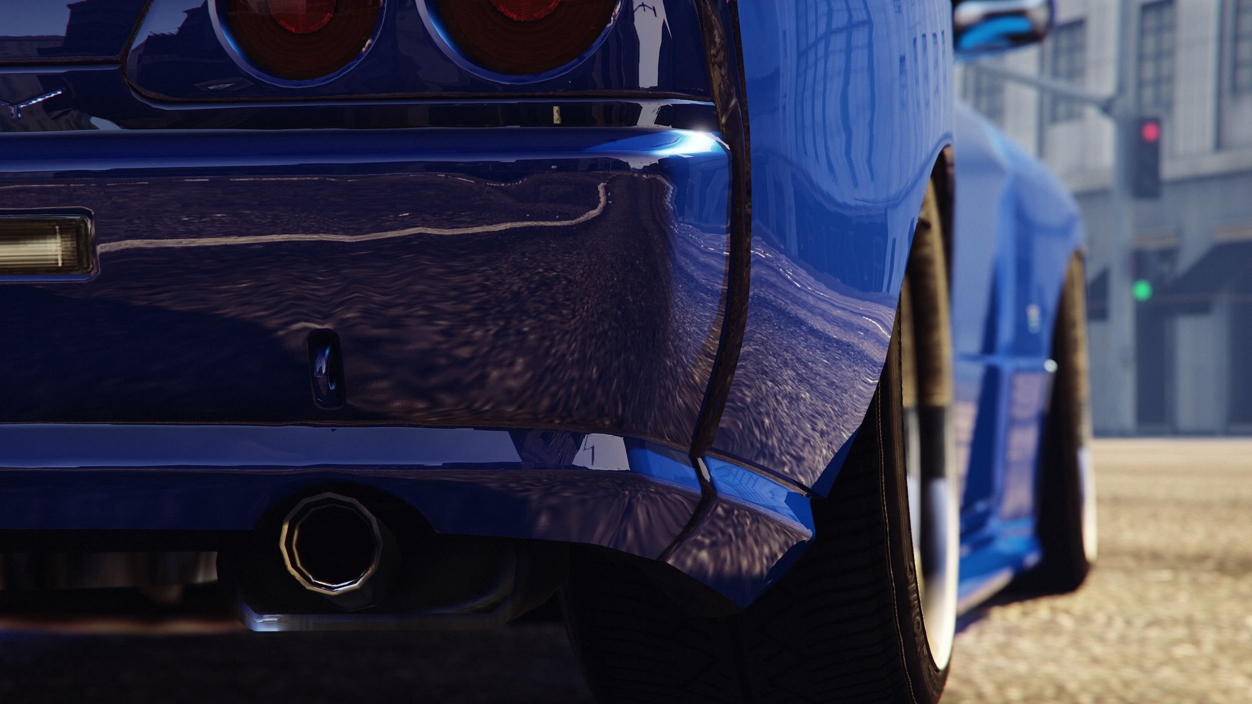 Close-up of the rear of a blue sports car with visible exhaust pipes, showing reflections on its shiny surface.