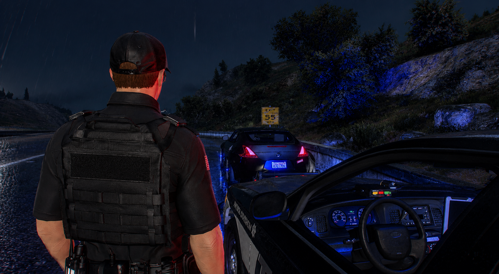 Nighttime scene on a rainy highway with police and patrol cars. A police officer is standing near the patrol vehicle, looking towards a black car stopped on the side of the road. The black car is parked near an exit sign indicating 55 MPH speed limit.
