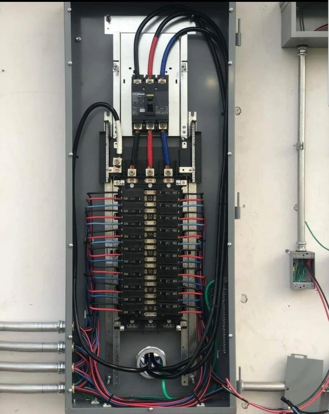 Electric panel with circuit breakers and wiring.