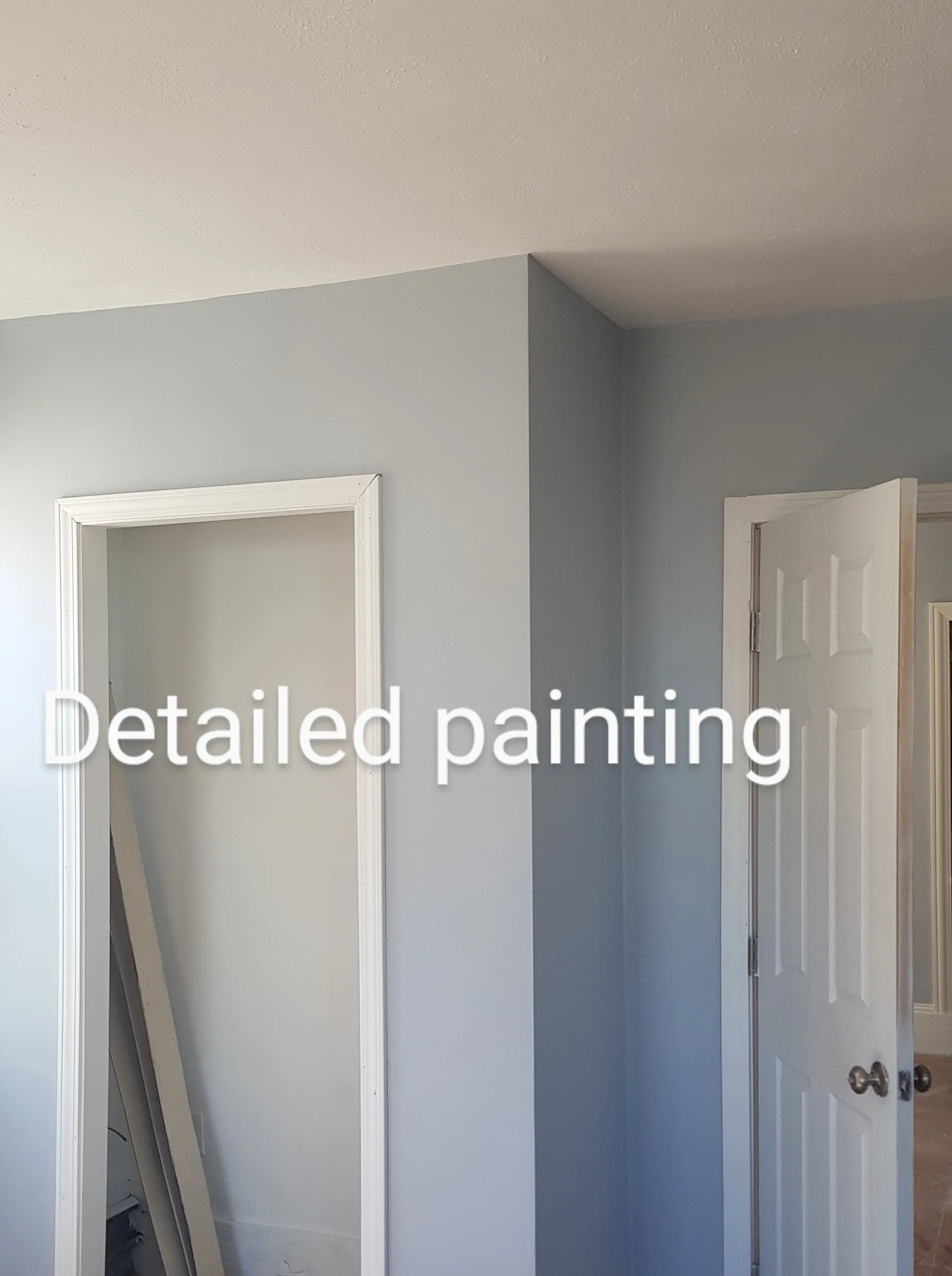 Interior of a room with light gray walls, white door frames, and an open white door, with a large mirror leaning against the wall.