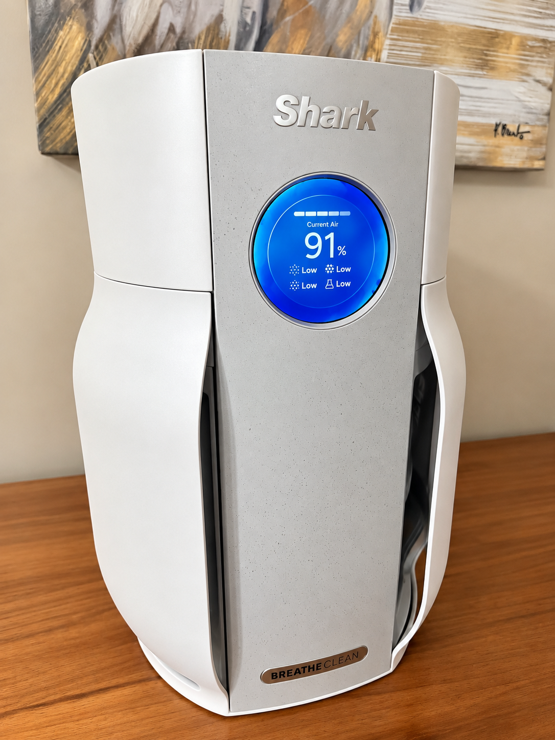 A Shark air purifier on a wooden surface, showing 91% current air quality with a blue circular display.