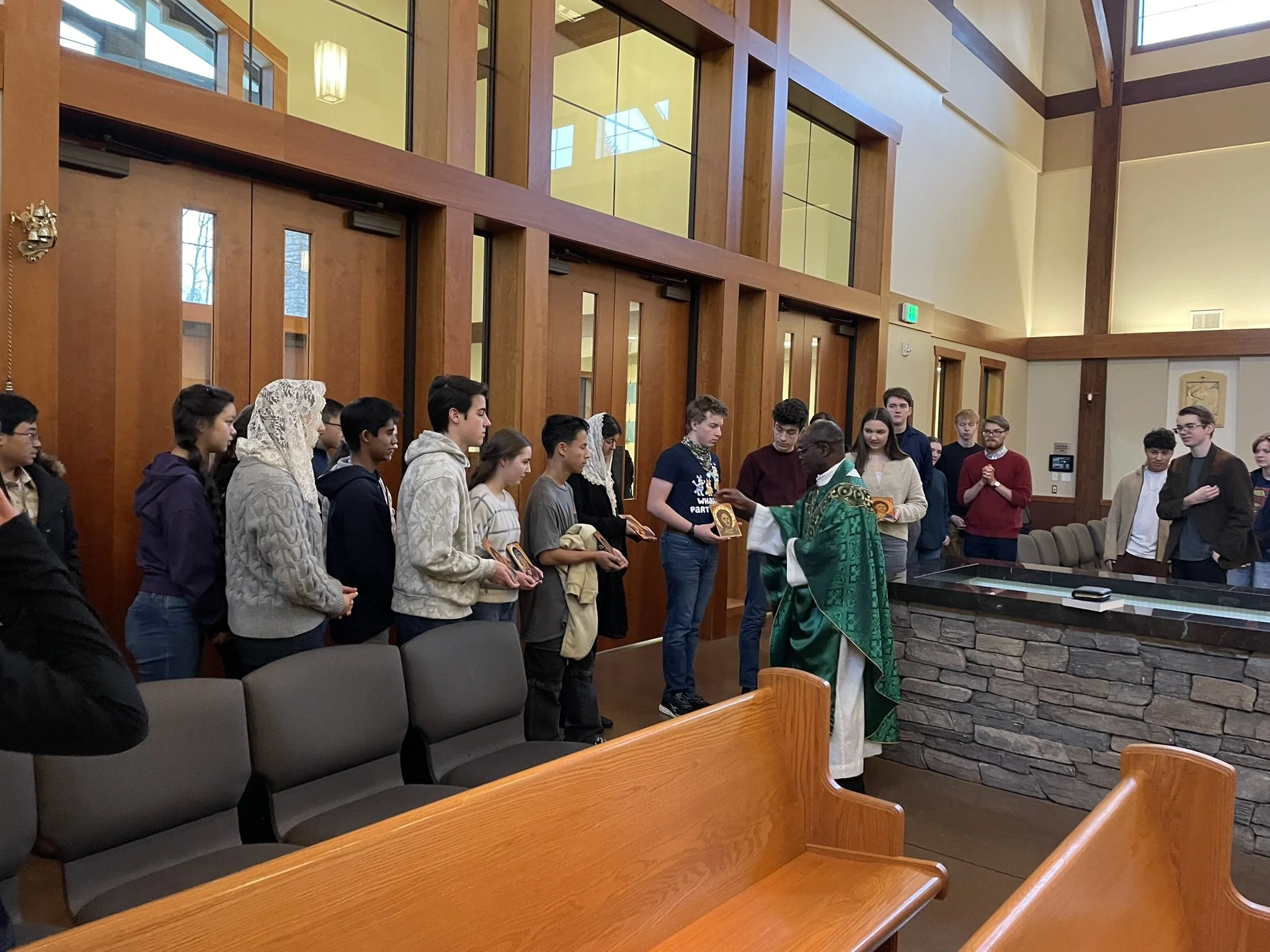 CASM students speaking with Father Peter at St. Theresa of Calcutta church