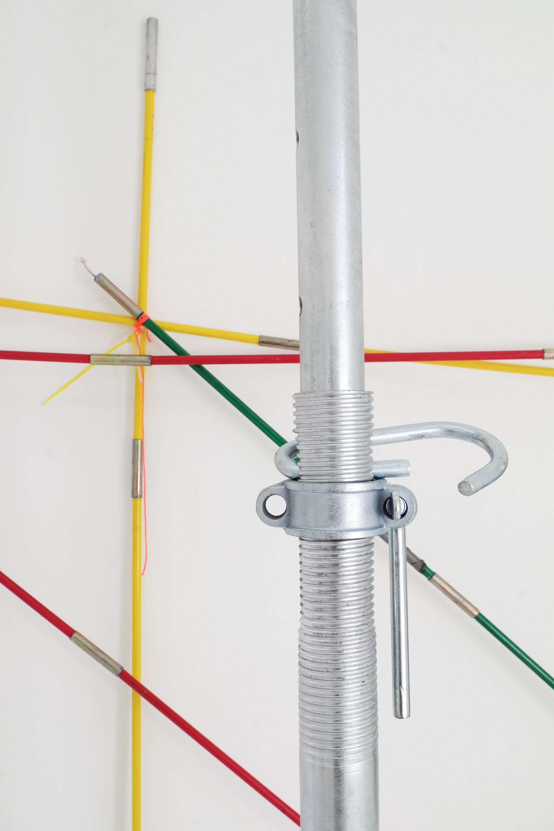 Close-up of a mechanical pipe fixture with colored wires in the background.