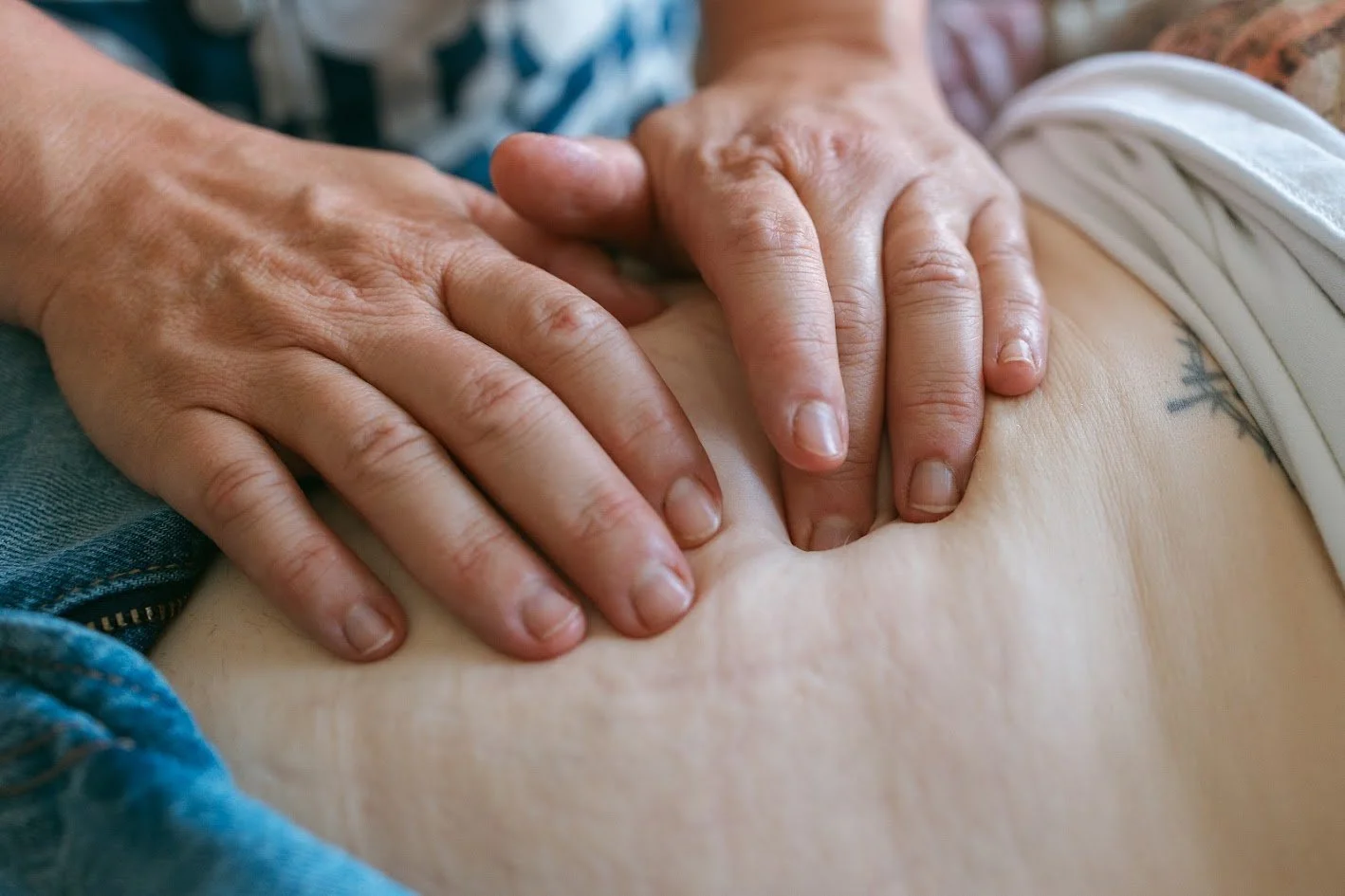Hands performing chest compressions on a person's bare chest during CPR.