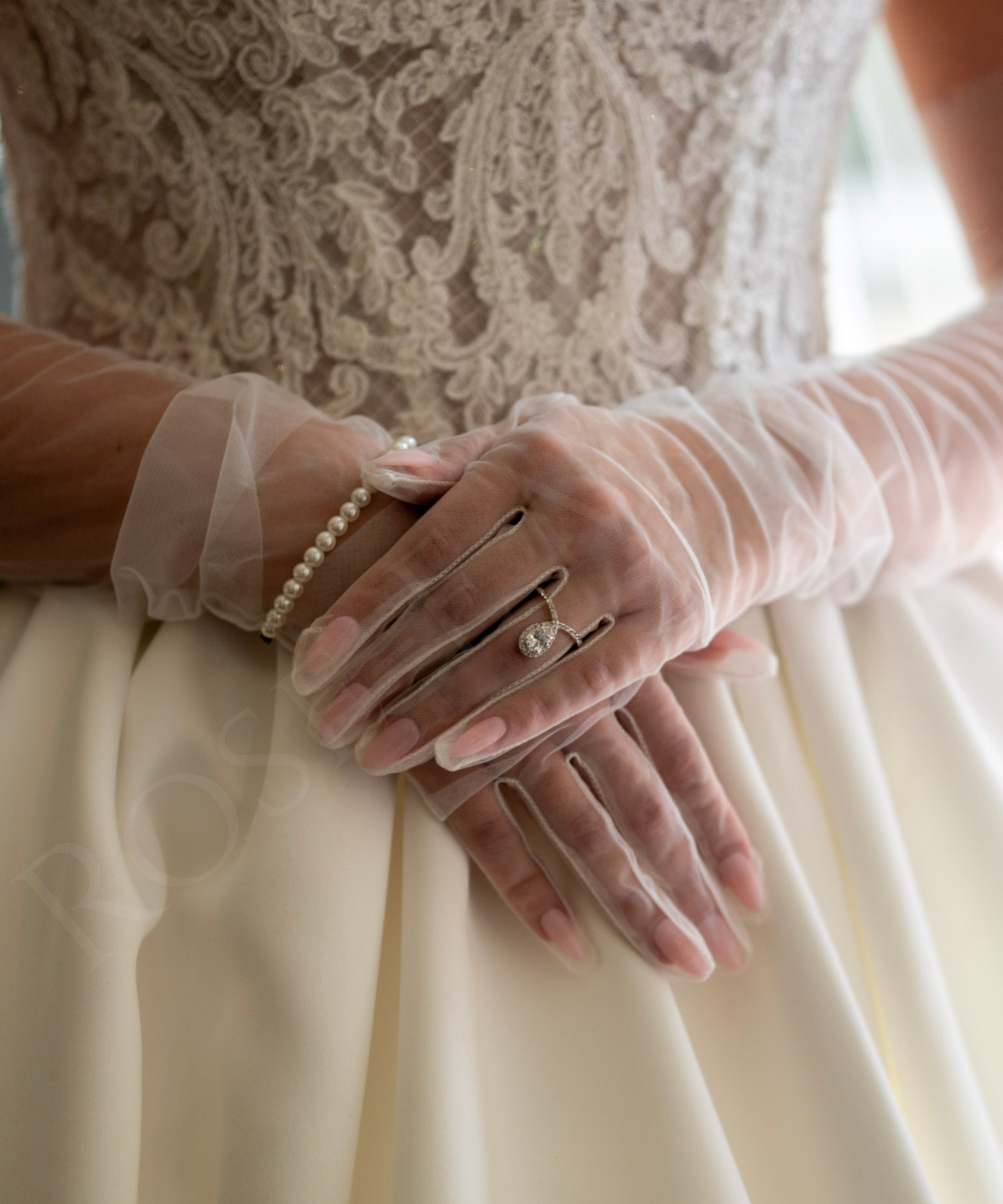 A close-up detail shot of the model’s hand, highlighting her rings as part of the styling and refined visual details of the editorial.