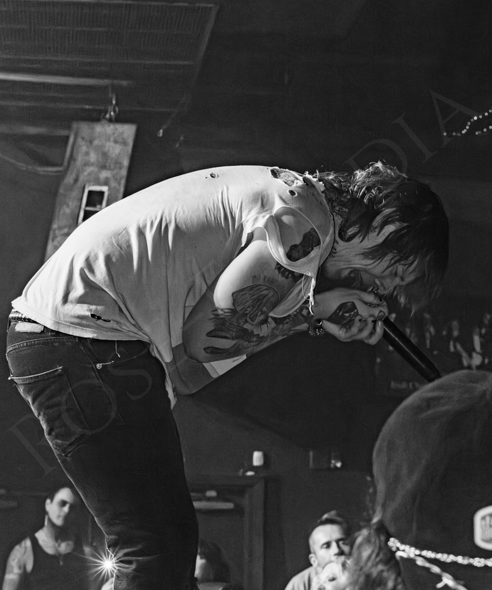 Sueco screaming into a microphone on stage during Bemo Rouge’s Emo Night in New Orleans.