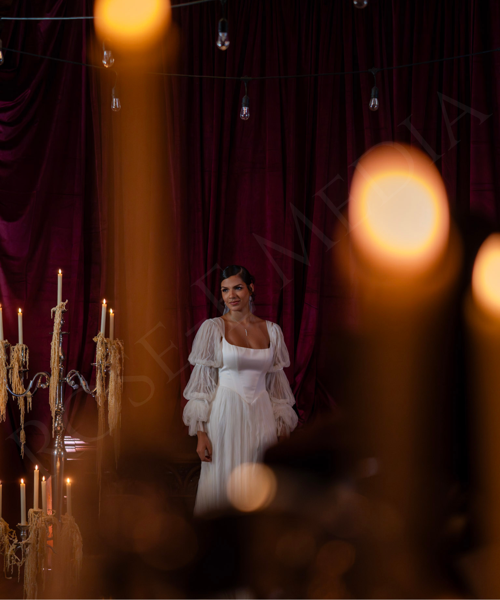 Model standing among glowing candles during a NOW Weddings editorial shoot at House of Blues New Orleans.