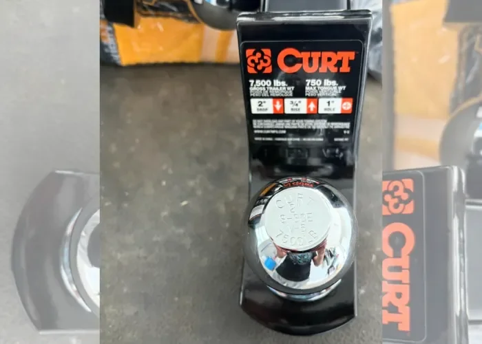 A Curt trailer hitch ball mount with a 2-inch ball, 3/4-inch rise, 1-inch shank, and a 7,500-pound weight capacity, mounted on a vehicle.