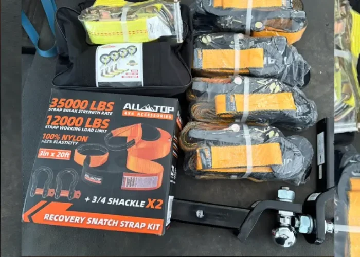 A recovery snatch strap kit includes a 3500 lb break strength recovery strap, a 1200 lb working load strap, two shackles, and additional hardware, all displayed with packaged straps and a ratchet tensioner on a dark surface.