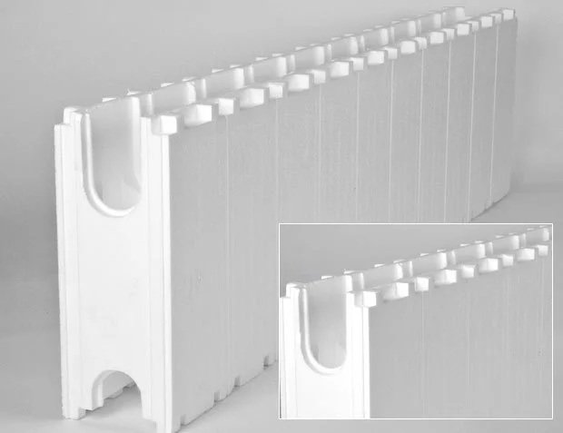 Close-up of a white plastic barrier with a curved top and gaps.