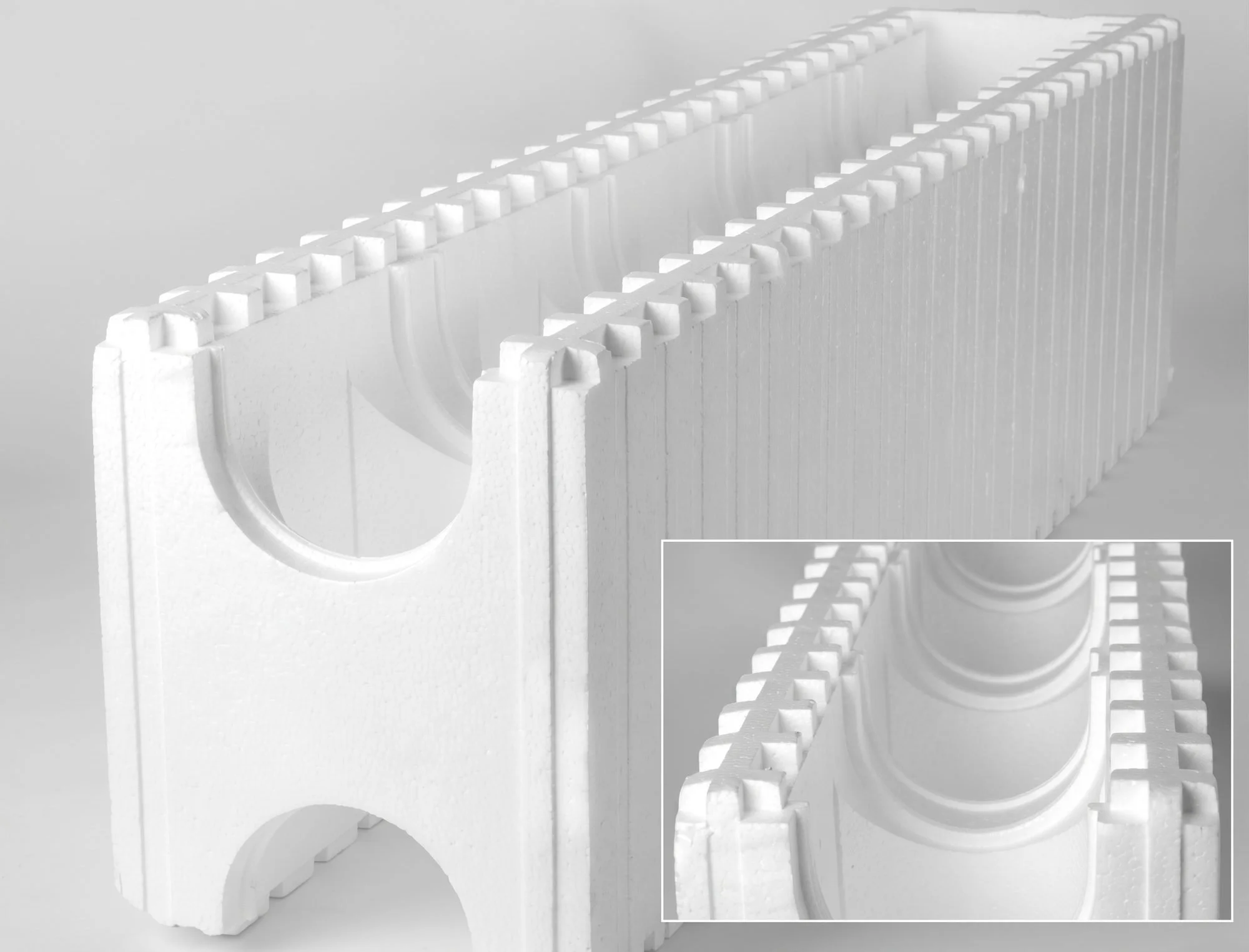 Close-up of white Styrofoam packaging inserts with circular and rectangular cutouts, arranged in a grid pattern.
