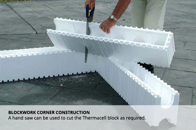 A person cutting a large white Thermacell block with a hand saw on a flat surface.