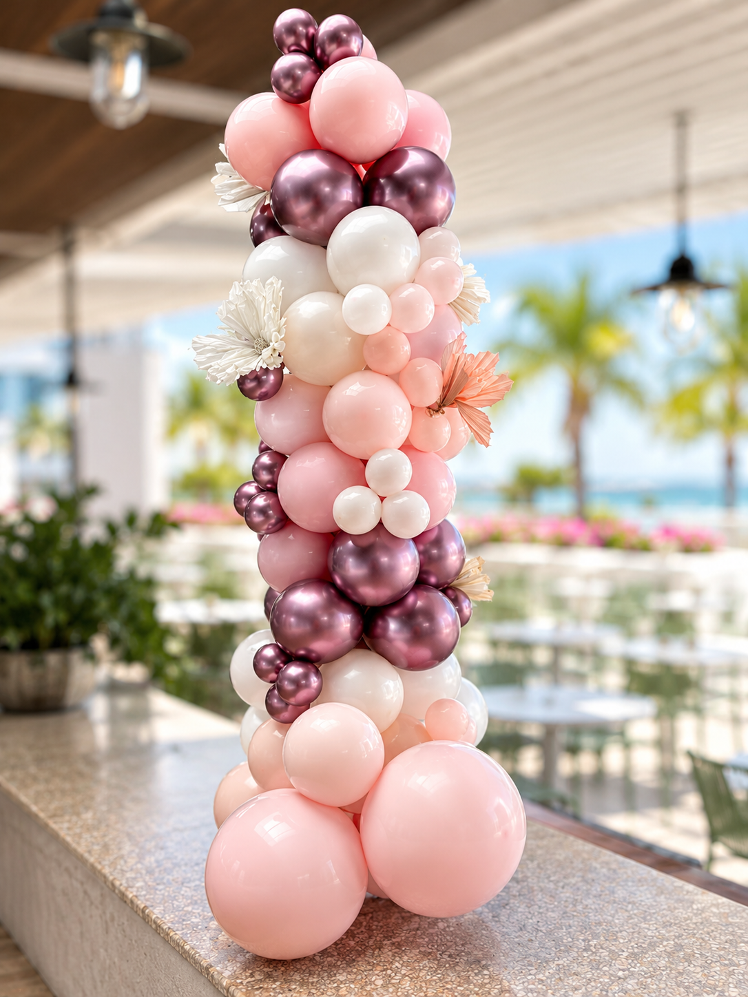 Handcrafted bridal balloon pillar in pink, white and metallic purple with floral accents — perfect for wedding aisles, photo backdrops, and reception decor. Townsville