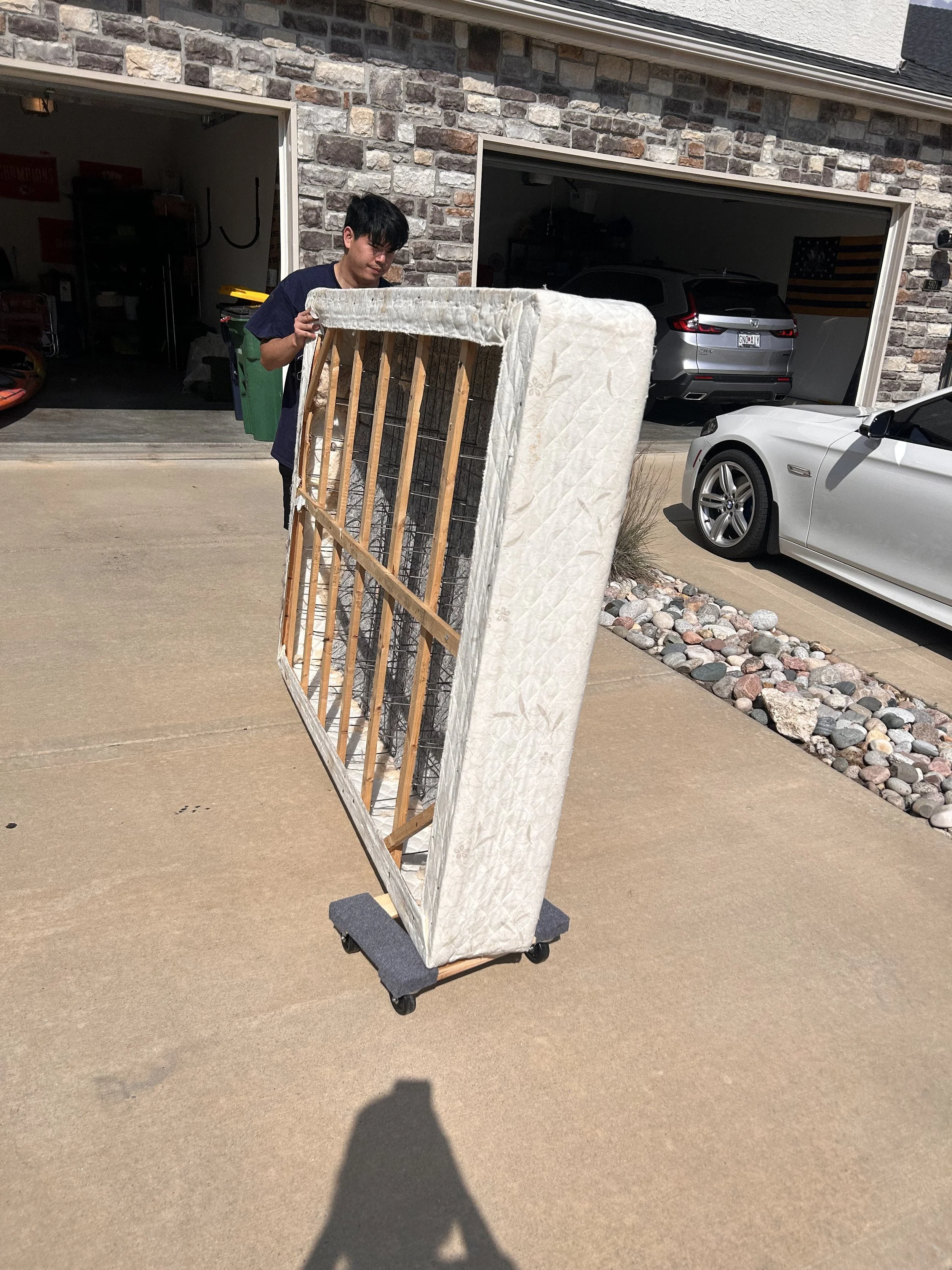 two people move a beige sofa out of a house
