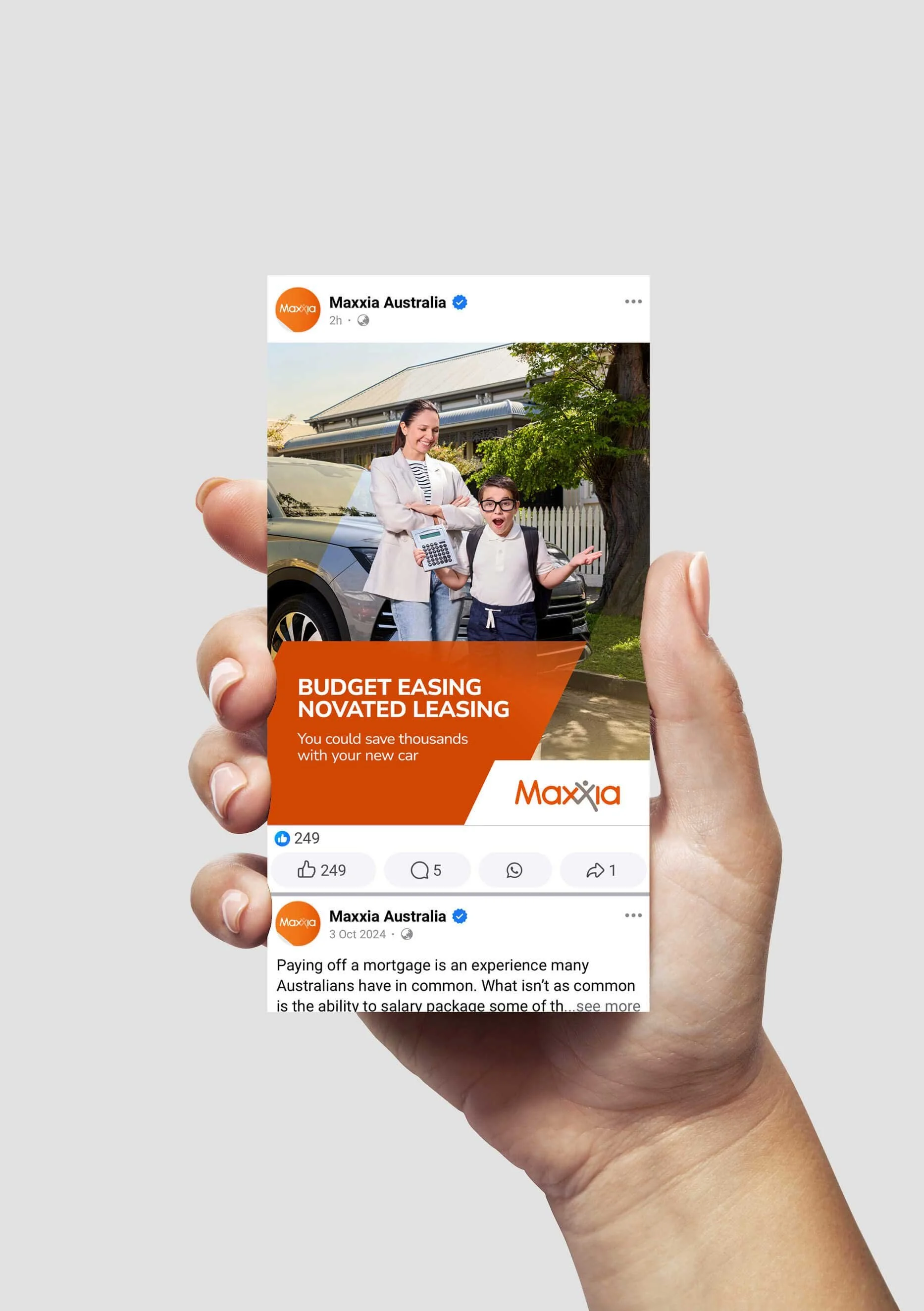 A hand holding a phone mock up of a Maxxia social ad