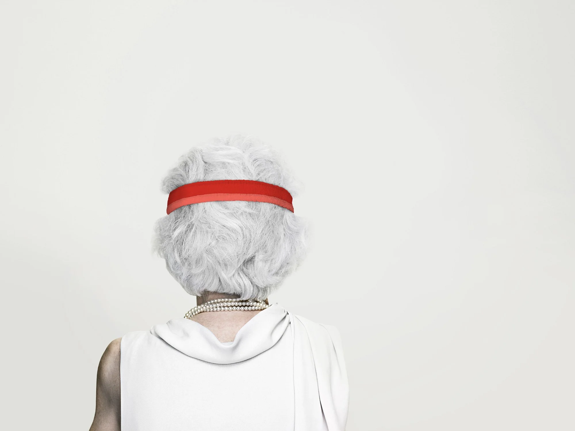 Photo of an elderly woman from behind wearing a red headband