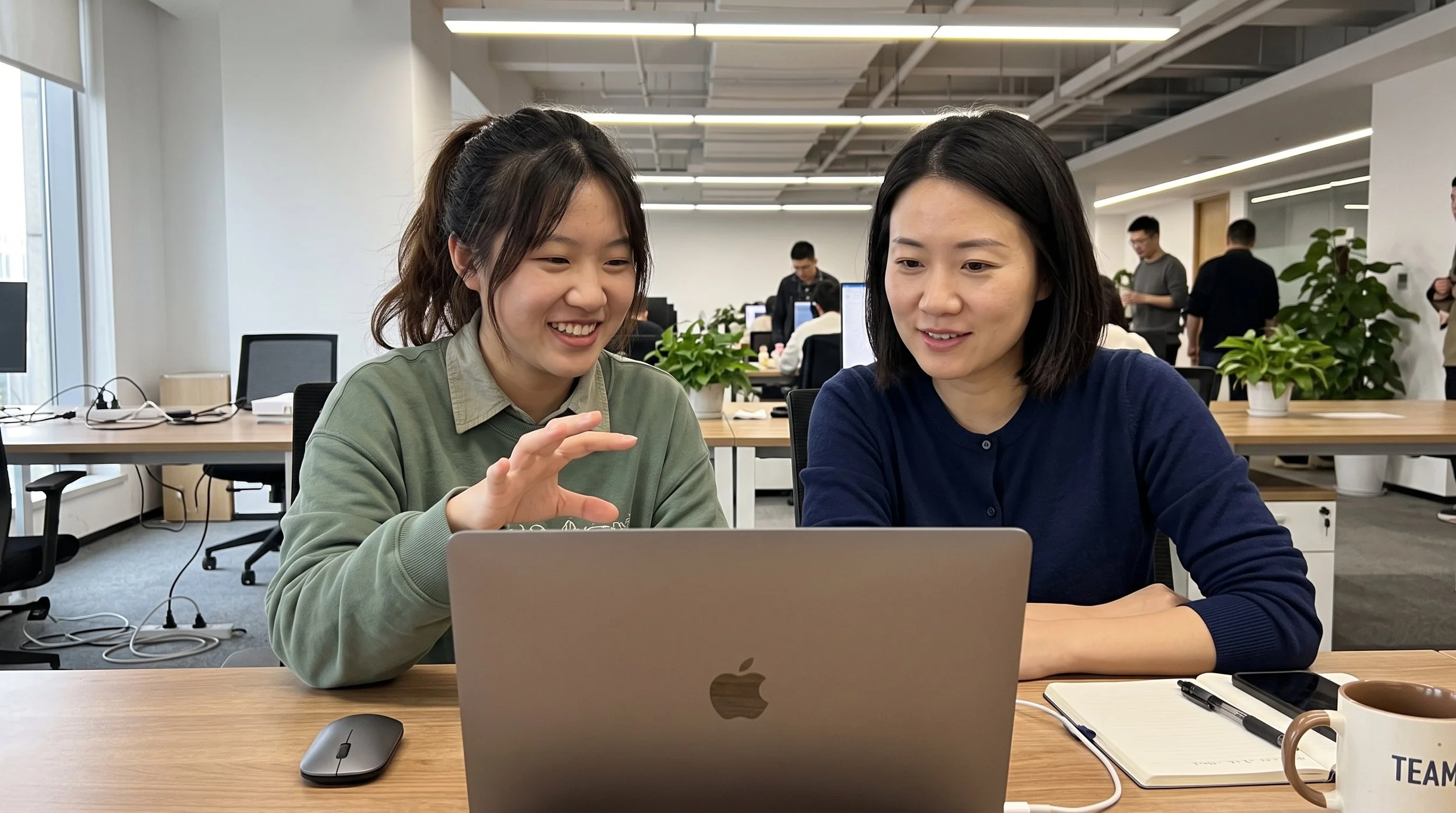 Senior mentor guiding young professional through project work.