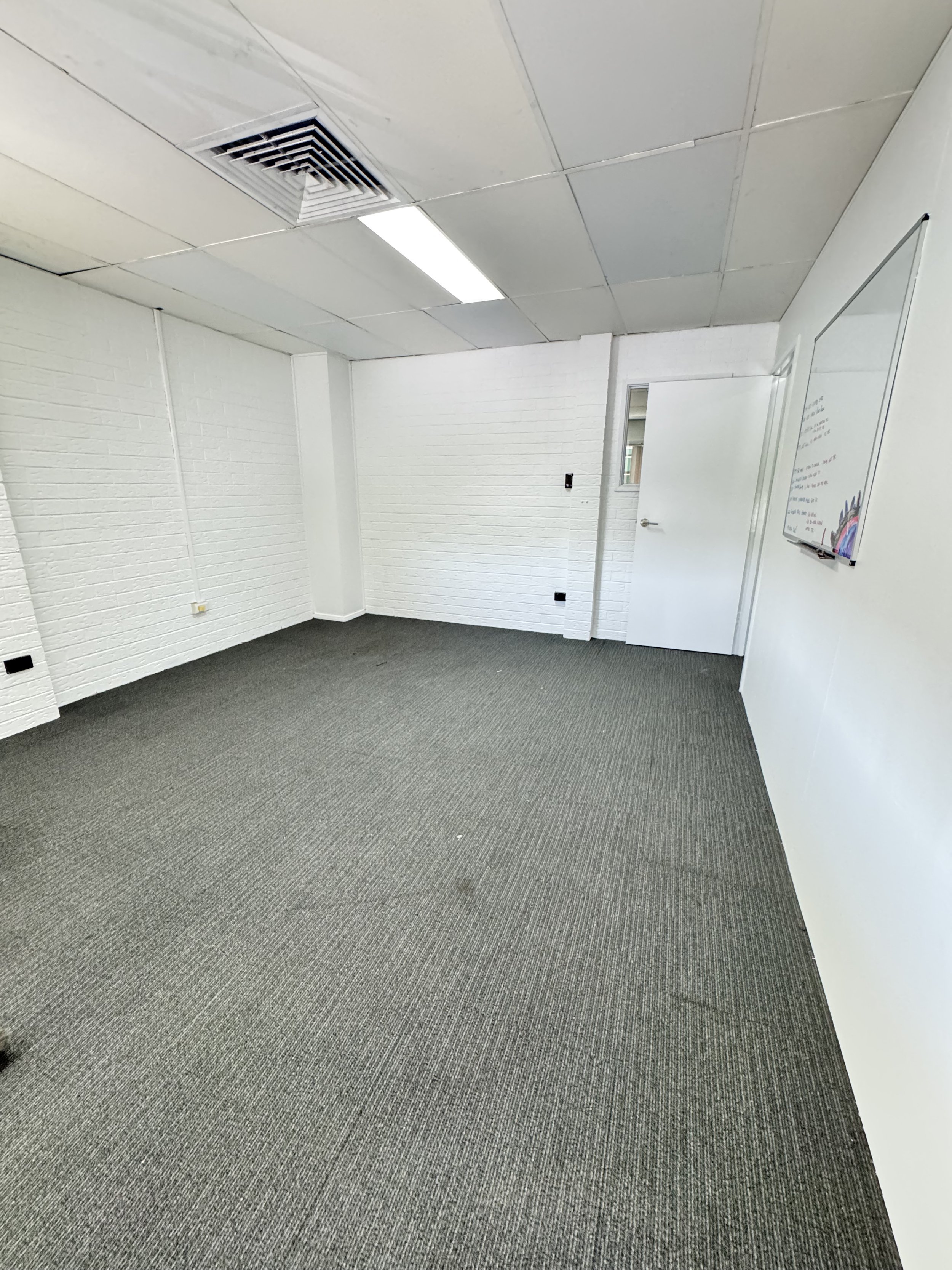Freshly painted office with white walls and grey carpet