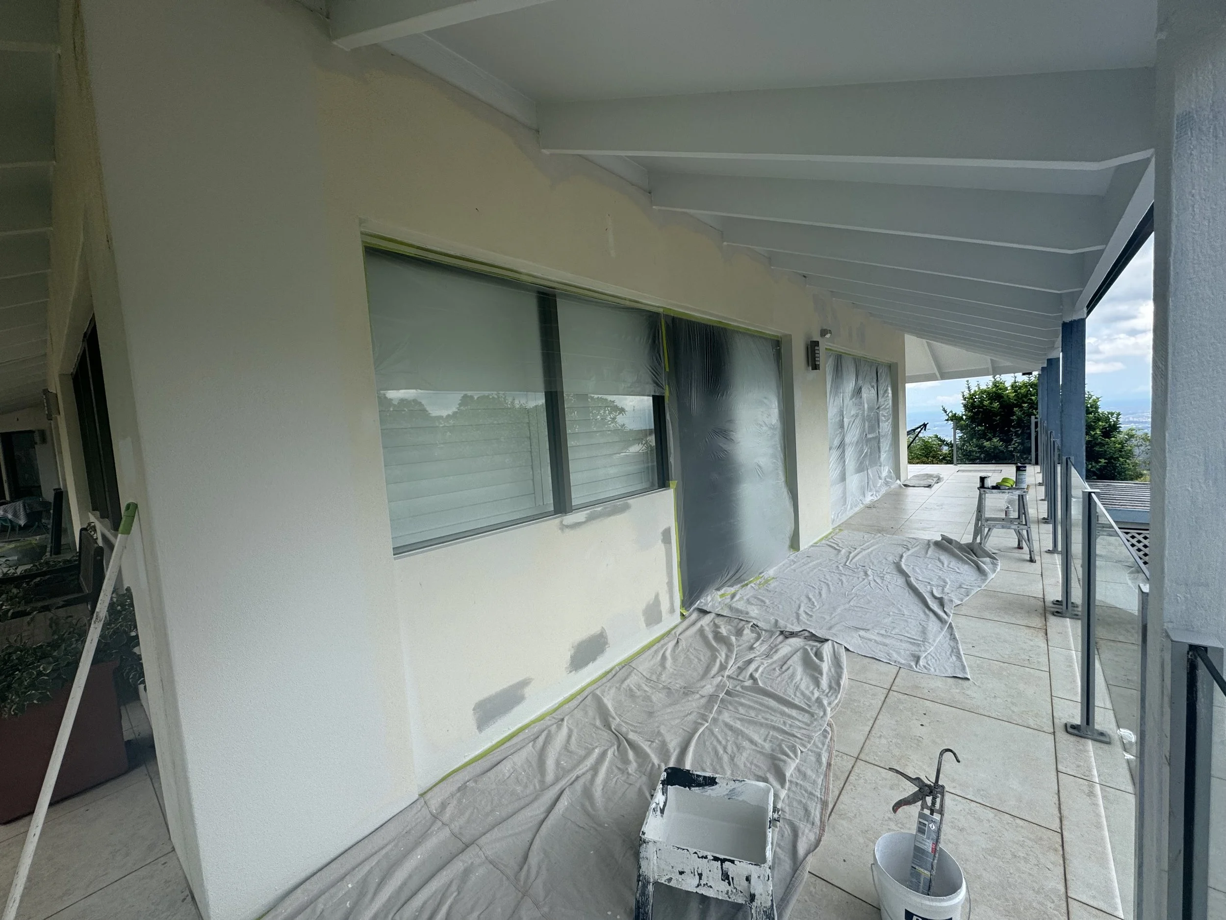 xterior balcony prepared for painting with protective coverings and painting equipment.