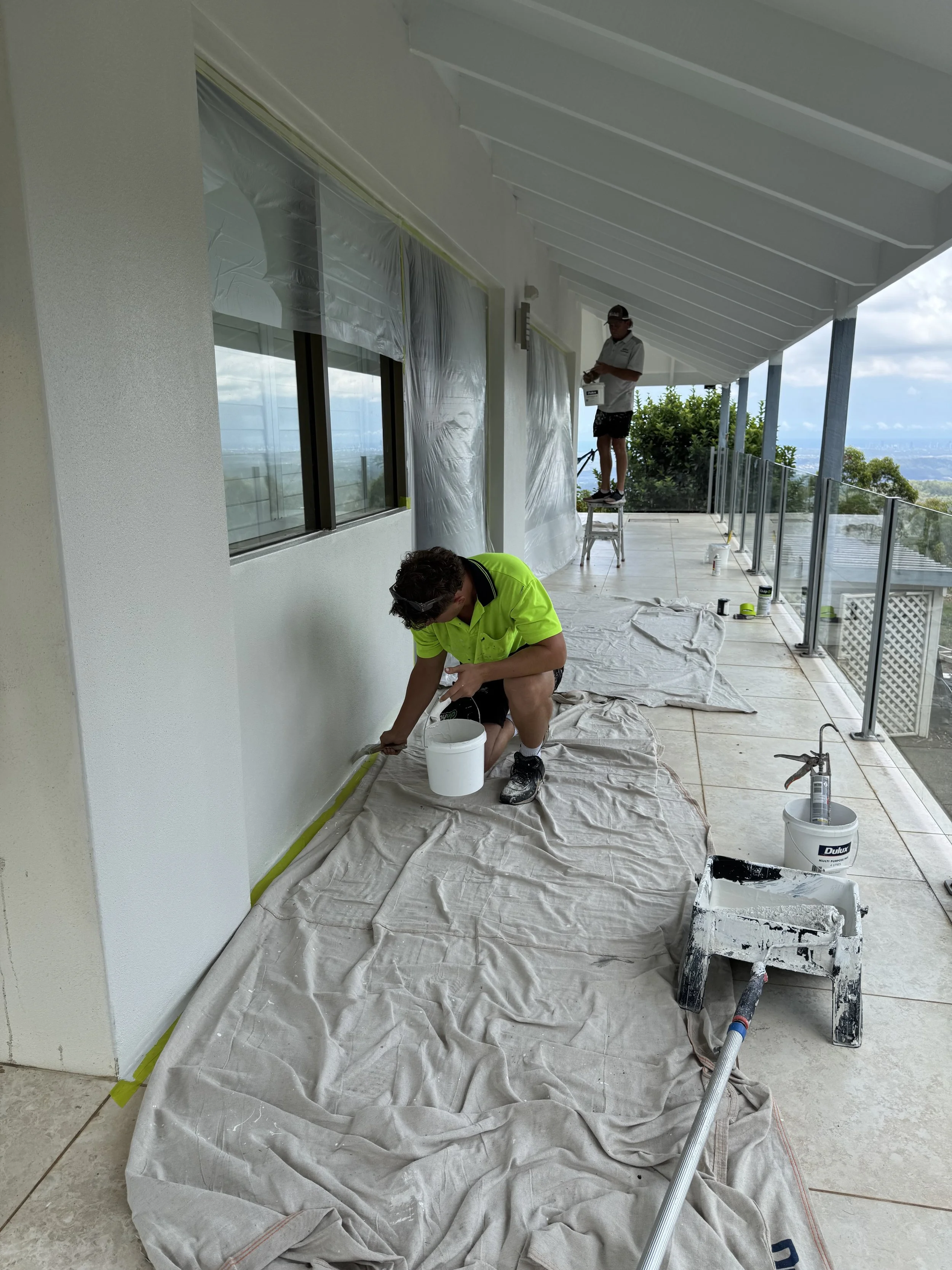 CAC Coatings painters completing exterior painting on a residential balcony.